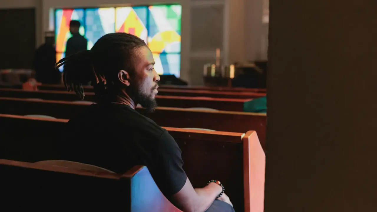 Man looking out of church | Religious Trauma | Elnita Ottey & Associates